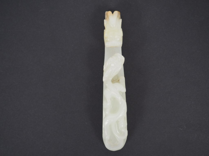 Ensemble de six fibules en jade blanc céladon décor de double dragon. 