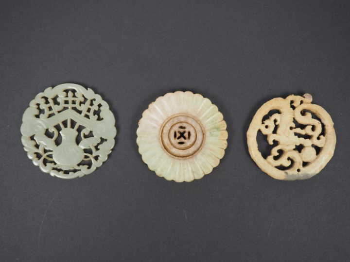 Lot comprenant : - un pendentif en jade céladon, à décor d'objets mobi