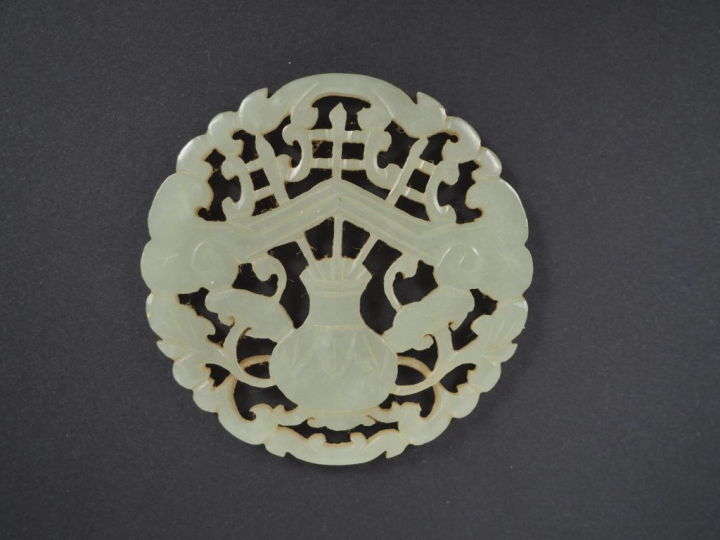 Lot comprenant : - un pendentif en jade céladon, à décor d'objets mobi