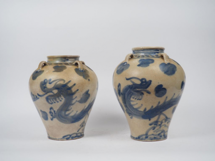 Deux jarres en céramique émaillée bleu sur fond craquelé beige, à déco