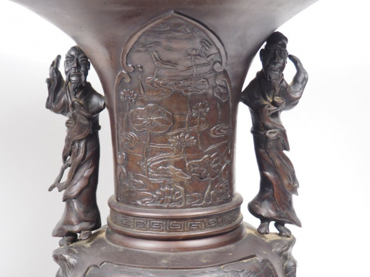 Paire de vases à large pavillon en bronze, à décor en léger relief de 