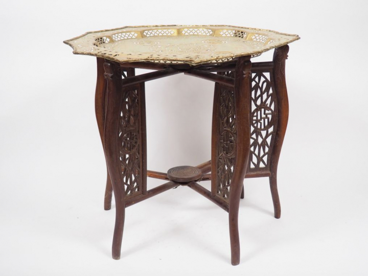 Guéridon en bois naturel, supportant un plateau en cuivre doré prenant