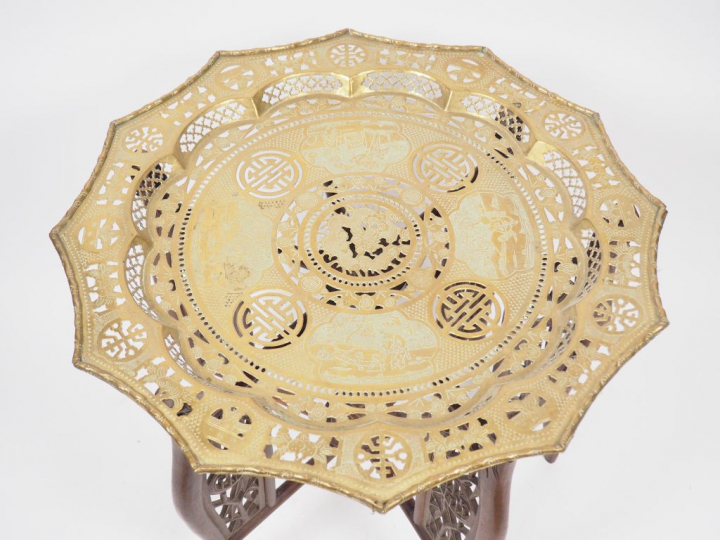 Guéridon en bois naturel, supportant un plateau en cuivre doré prenant