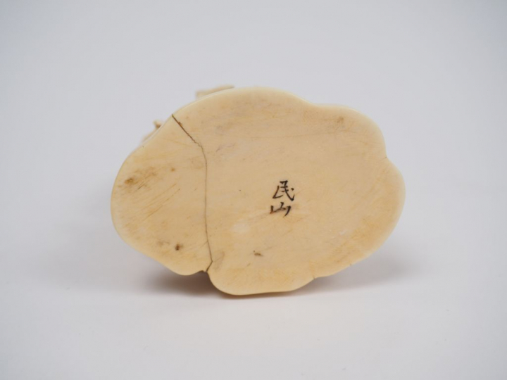 Okimono en ivoire représentant un maraicher tenant un instrument arrat