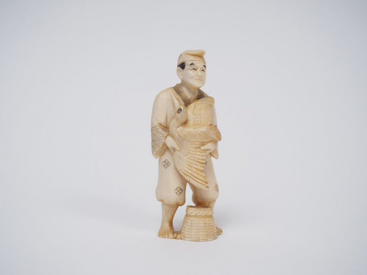 Okimono en ivoire marin représentant un pêcheur au cormoran.  Japon, v