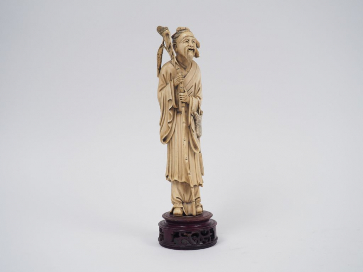 Statuette en ivoire représentant un pêcheur tenant un bambou auquel es