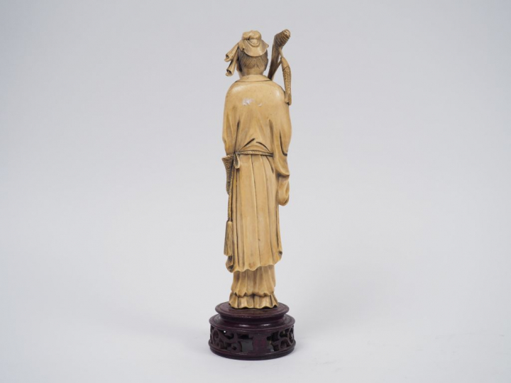 Statuette en ivoire représentant un pêcheur tenant un bambou auquel es