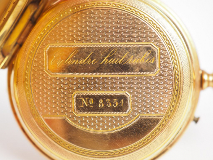 Montre de col en or jaune, à décor gravé et émaillé noir au revers d'u