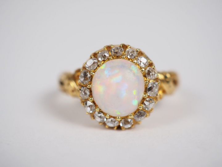 Bague marguerite en or jaune, ornée en son centre d'une opale entourée