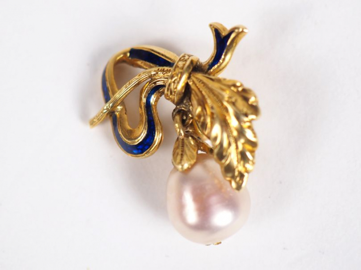 Pendentif en or jaune et émail bleu, à décor d'un nœud de ruban retena