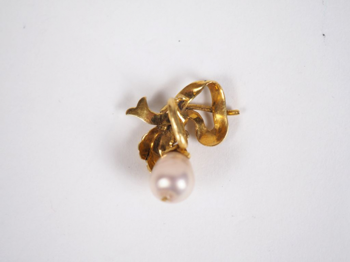 Pendentif en or jaune et émail bleu, à décor d'un nœud de ruban retena