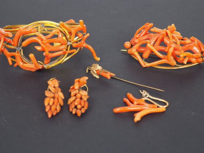 Parure en métal doré et corail, comprenant :  - un bracelet  - une bro
