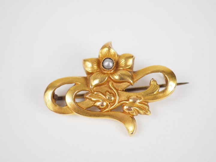 Broche en or jaune, à décor d'une fleur ornée d'une perle en son centr