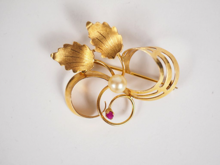 Broche en or jaune et perle, à décor de feuillage stylisé. Poids tel. 