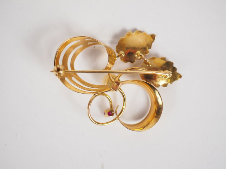 Broche en or jaune et perle, à décor de feuillage stylisé. Poids tel. 