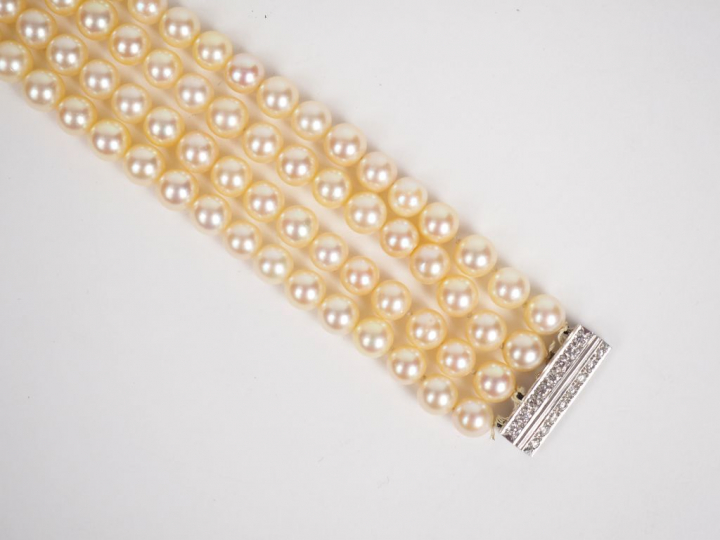 Bracelet quatre rangs de perles. Fermoir en or blanc, orné de deux lig