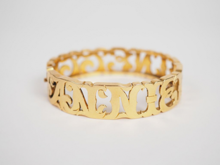 Bracelet en or jaune, à décor ajouré de lettres entrelacées.  5 x 5,8 