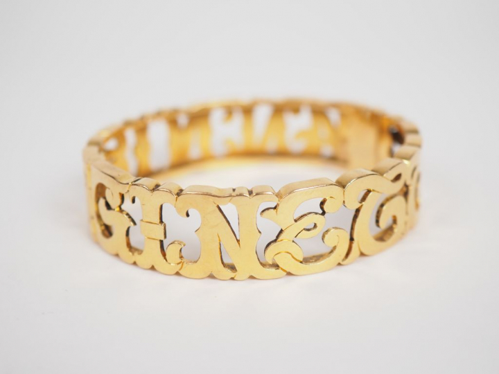 Bracelet en or jaune, à décor ajouré de lettres entrelacées.  5 x 5,8 