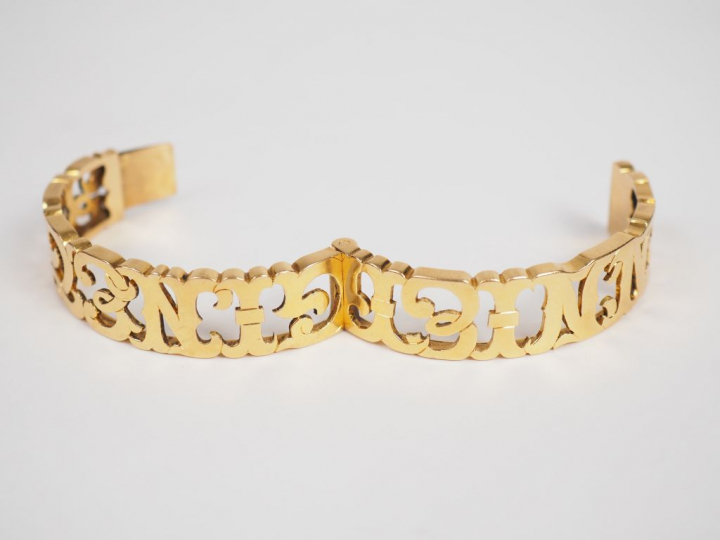 Bracelet en or jaune, à décor ajouré de lettres entrelacées.  5 x 5,8 