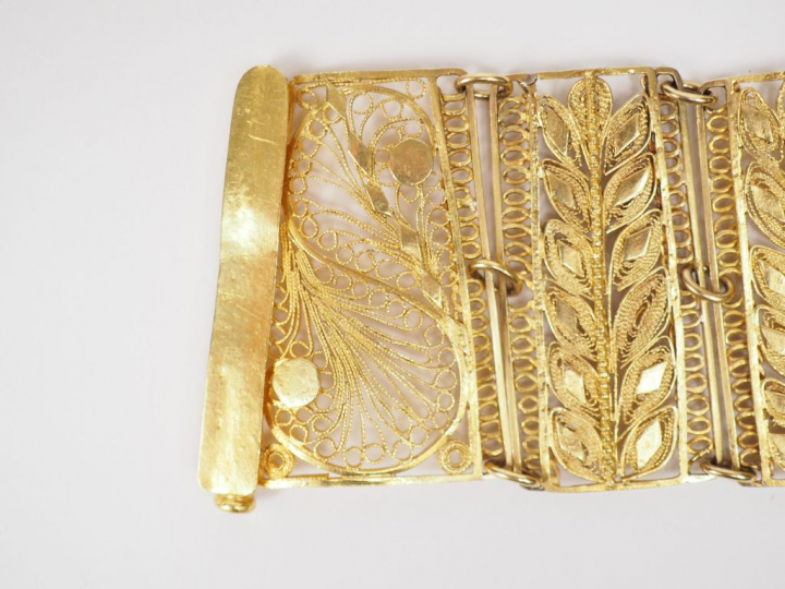 Bracelet manchette en or jaune, à décor ajouré et filigrané de feuilla