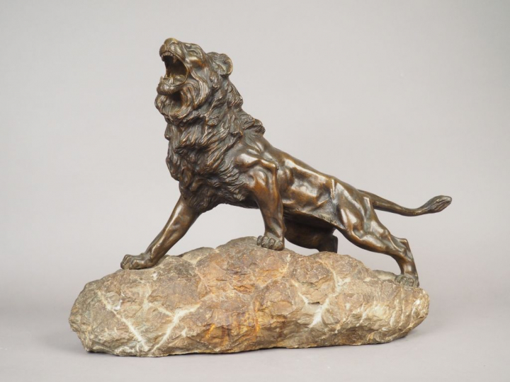 ANDREY. "Lion rugissant sur un rocher" Sculpture en bronze à patine br