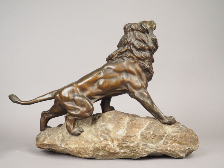 ANDREY. "Lion rugissant sur un rocher" Sculpture en bronze à patine br