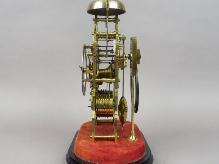 Pendule squelette de style Louis XIV en bronze sous globe. H. 40,5 cm