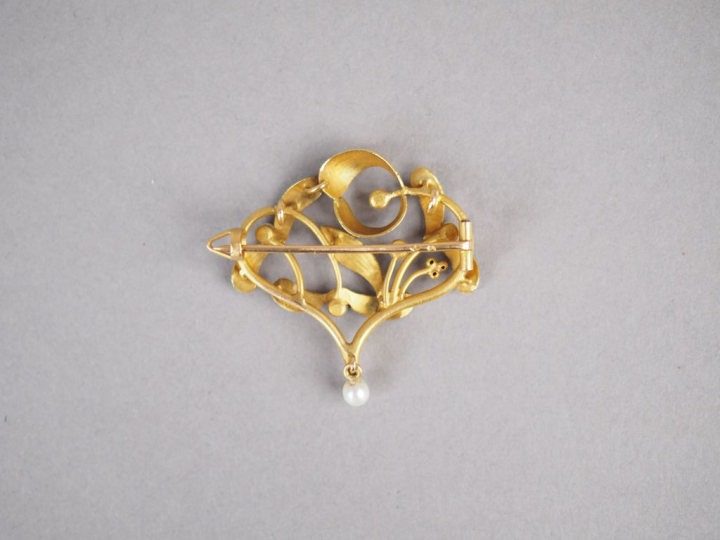 Broche de style Art Nouveau en or jaune et perles, à décor ajouré de g