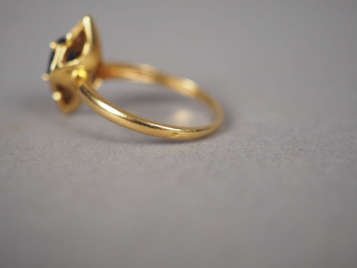 Bague en or jaune en forme de fleur, ornée en son centre d'un saphir e