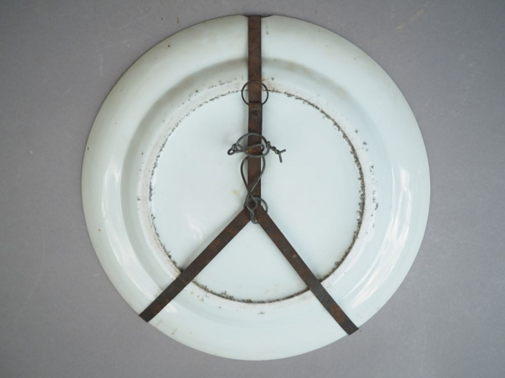 Assiette en porcelaine et émaux polychrome, à décor de paysage, marli 