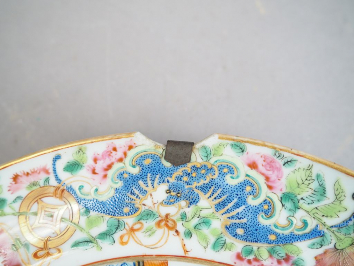 Assiette en porcelaine et émaux polychrome, à décor de paysage, marli 