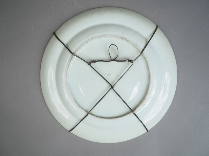 Assiette en porcelaine et émaux polychrome, à décor en plein de person