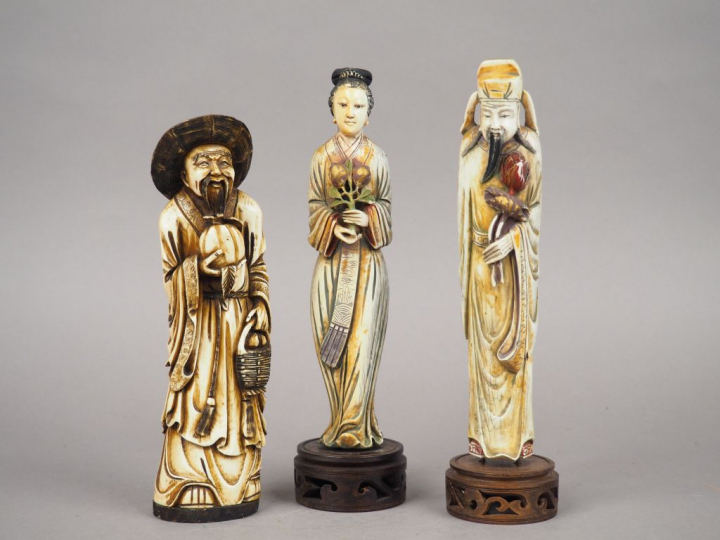 Ensemble comprenant trois statuettes en ivoires polychrome représentan