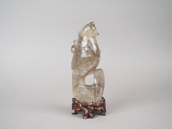 Statuette en cristal de roche fumé figurant une perruche posée sur un 