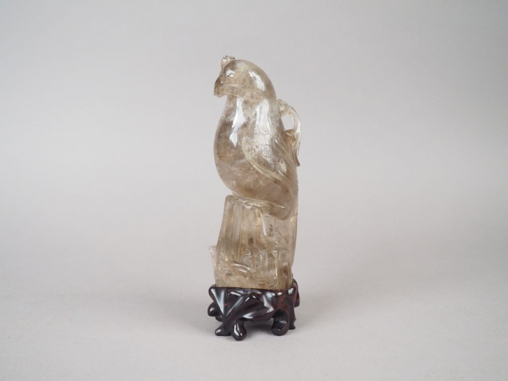 Statuette en cristal de roche fumé figurant une perruche posée sur un 