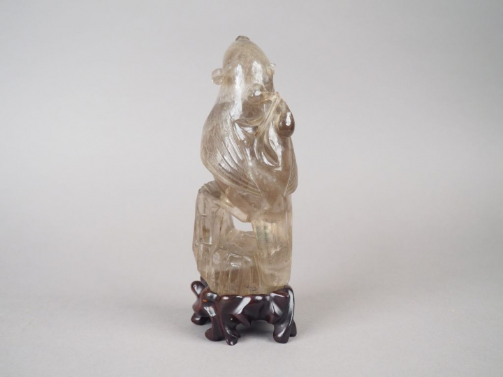 Statuette en cristal de roche fumé figurant une perruche posée sur un 