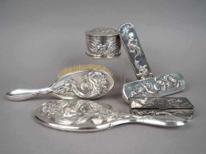 Partie de nécessaire de toilette en argent, à décor en relief de drago