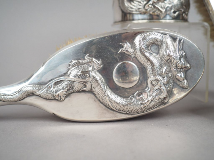 Partie de nécessaire de toilette en argent, à décor en relief de drago