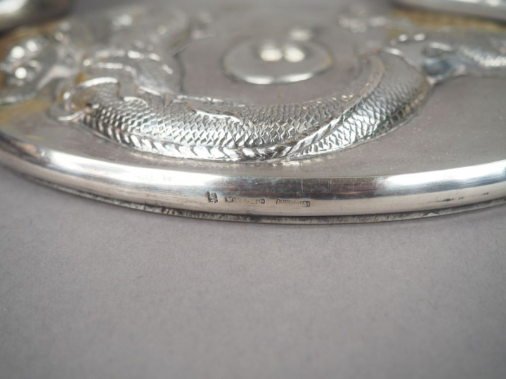 Partie de nécessaire de toilette en argent, à décor en relief de drago