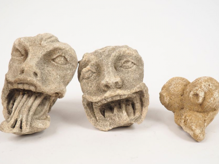 	Deux têtes de monstres grimaçants en pierre sculptée, on joint un élé