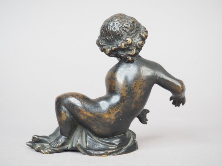 Enfant allongé en bronze patiné. XIXème siècle. H. 12 cm (fissure au c