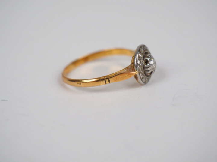 Bague en or jaune, ornée en son centre d'un petit diamant entouré de r