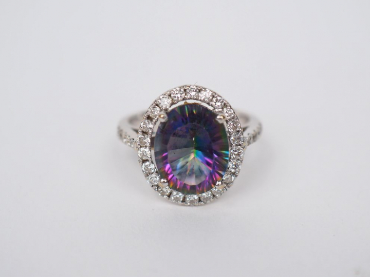 Bague en or blanc sertie en son centre d'une pierre entourée de petits