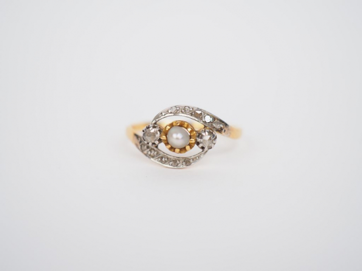 Bague en or jaune, ornée en son centre d'une perle entourée de petits 