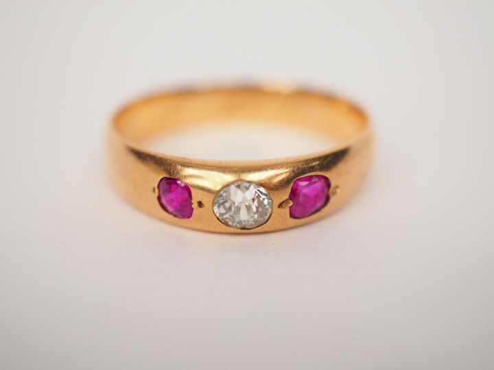 Bague en or jaune ornée en son centre d’une rose épaulée de deux pierr