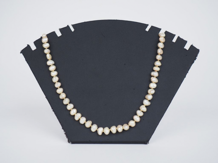 Collier de perles baroques.  Fermoir en métal doré, orné en son centre