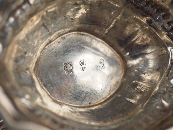 Saucière en argent étranger, à décor de masques et de rinceaux feuilla
