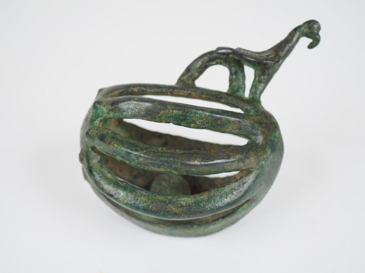 Grelot ovoïde surmonté d’un oiseau et d’un anneau de suspension. Luris