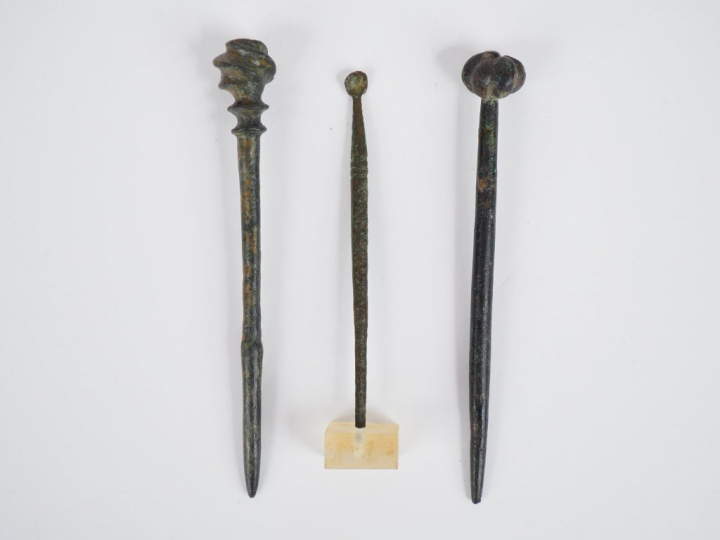 Trois épingles antiques en bronze. H. : 9 cm, 8.7 cm, 6.5 cm