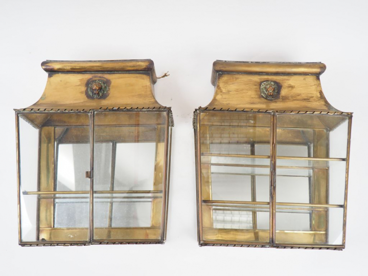 Paire de vitrines murales en verre et laiton à décor de mufles de lion